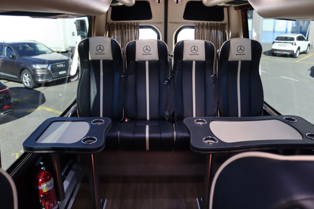 Innenraum eines Mercedes Sprinter mit Sitzgruppe und Tischen